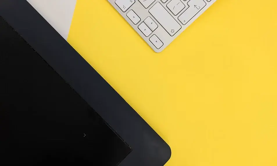 Monitor and keyboard on a yellow desk